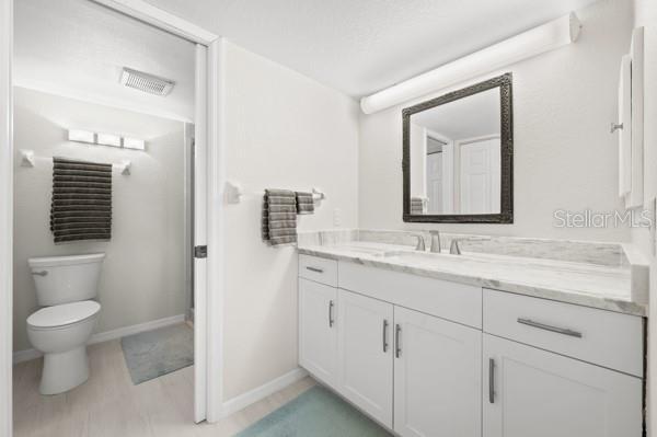 bathroom with vanity, a textured ceiling, and toilet