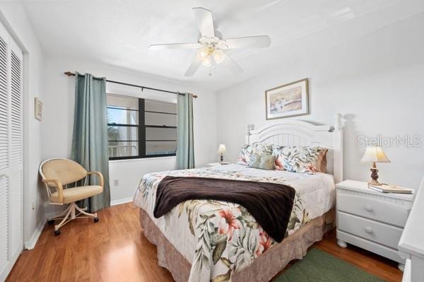 bedroom with hardwood / wood-style flooring, ceiling fan, and a closet