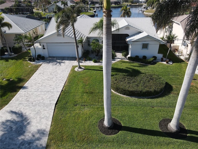 view of front of home with a water view, a front yard, and a garage