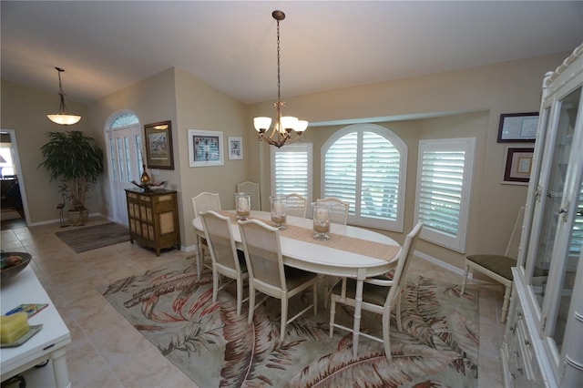 tiled dining space with lofted ceiling and a notable chandelier