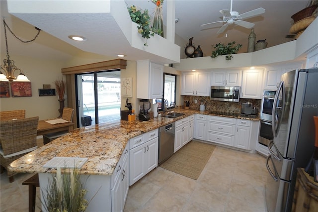 kitchen featuring white cabinets, appliances with stainless steel finishes, kitchen peninsula, and sink