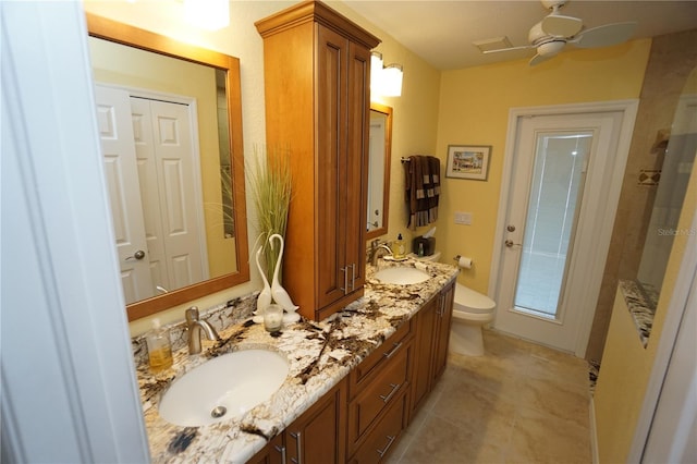 bathroom with tile patterned flooring, vanity, ceiling fan, and toilet