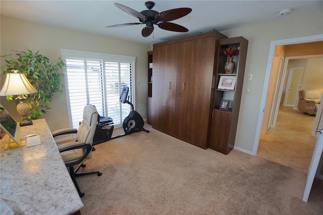 carpeted office space with ceiling fan