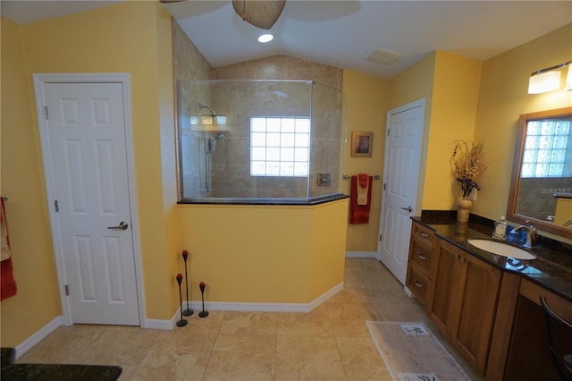 bathroom featuring vanity, ceiling fan, tiled shower, tile patterned flooring, and lofted ceiling