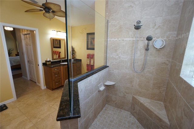 bathroom featuring vanity, ceiling fan, lofted ceiling, and tiled shower