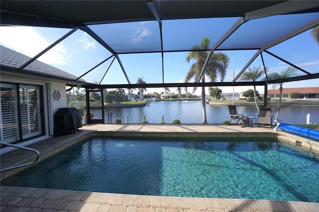 view of swimming pool with a lanai, a grill, and a water view