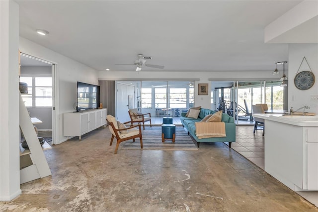 living room with concrete flooring, plenty of natural light, and ceiling fan