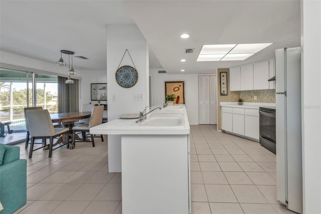 kitchen with white cabinets, white refrigerator, backsplash, and sink