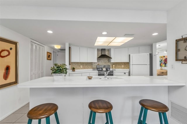 kitchen with a kitchen breakfast bar, white fridge, and wall chimney exhaust hood