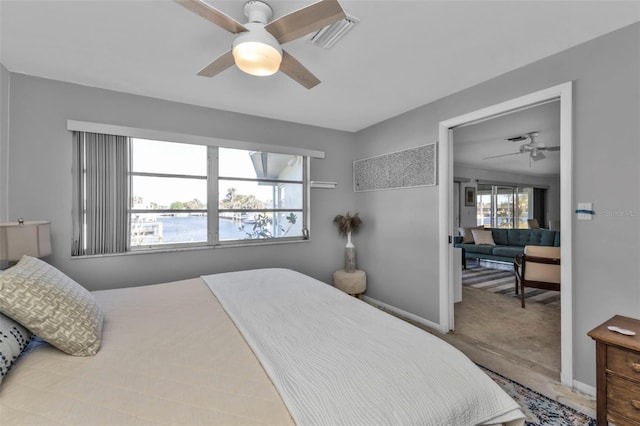 bedroom with a water view and ceiling fan