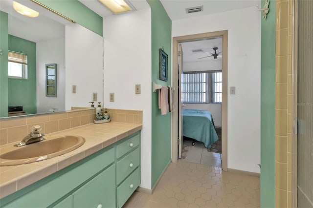 bathroom featuring tile patterned floors, decorative backsplash, vanity, and a wealth of natural light