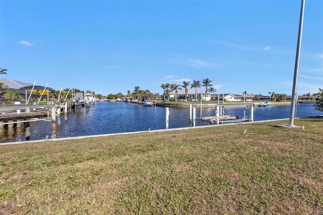 view of dock featuring a lawn and a water view