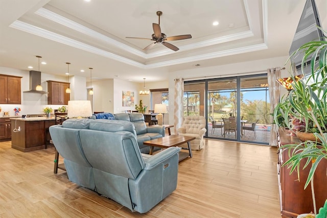 living room with a tray ceiling and light wood-type flooring