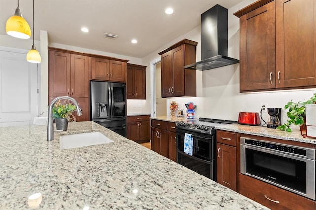 kitchen with sink, appliances with stainless steel finishes, hanging light fixtures, light stone counters, and wall chimney exhaust hood