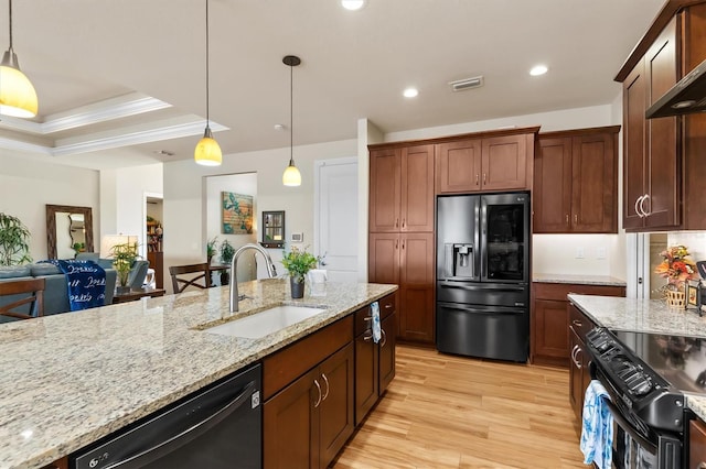 kitchen featuring pendant lighting, light stone countertops, sink, and black appliances