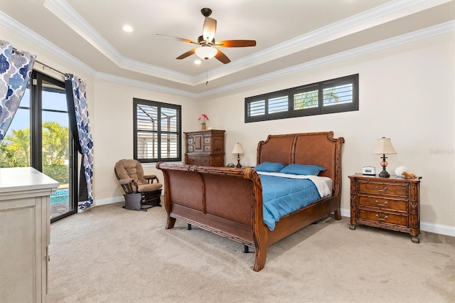 carpeted bedroom with ornamental molding, access to exterior, ceiling fan, and a tray ceiling