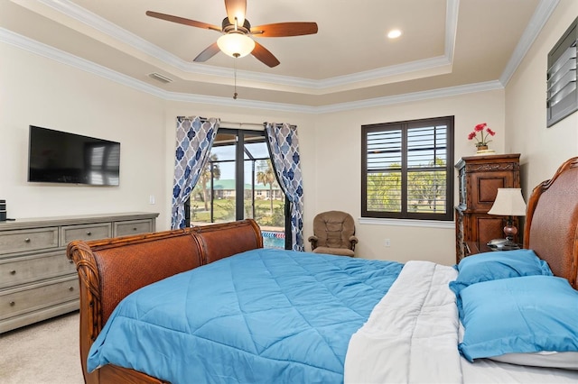 bedroom with a raised ceiling, multiple windows, and access to outside