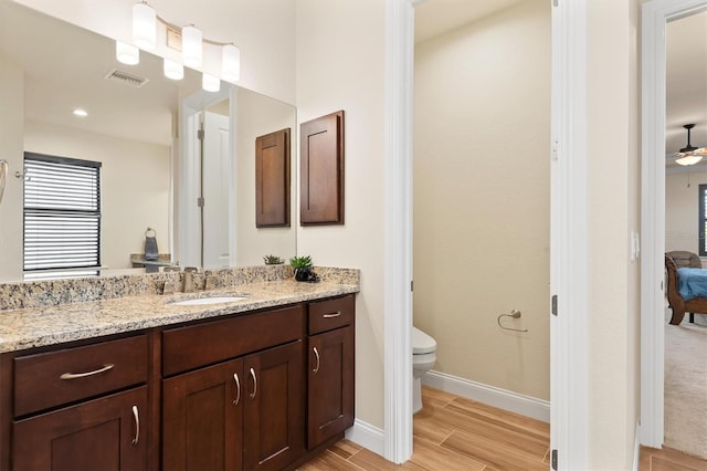 bathroom with ceiling fan, vanity, toilet, and hardwood / wood-style floors