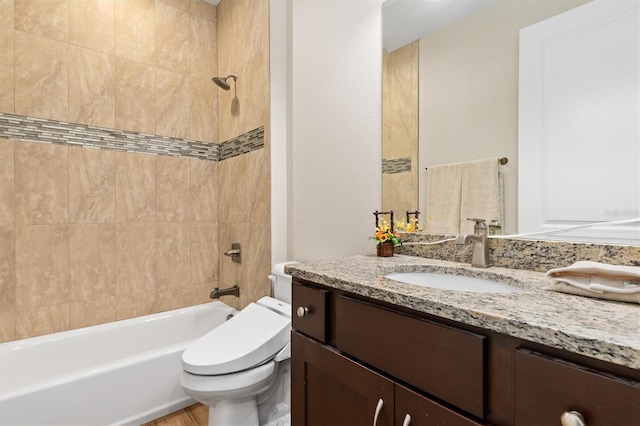 full bathroom with tiled shower / bath combo, vanity, and toilet