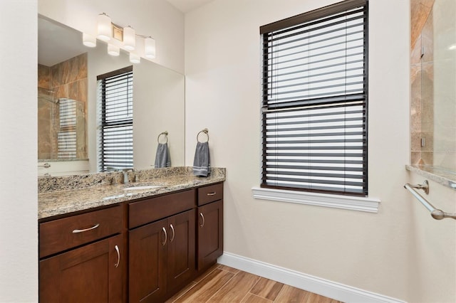 bathroom with vanity, hardwood / wood-style floors, and a shower with shower door