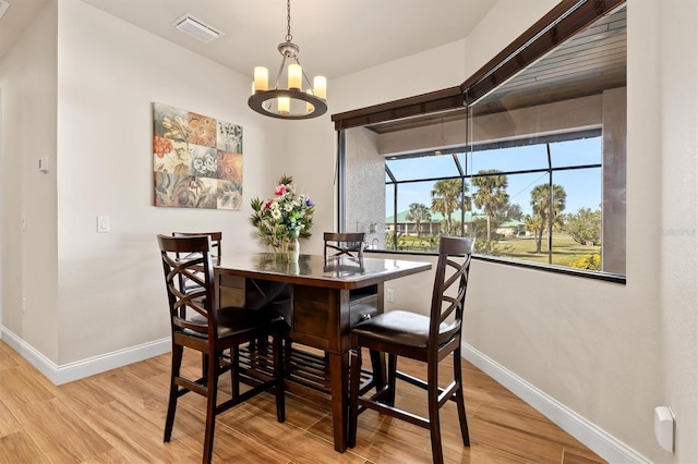 dining room with a chandelier and light hardwood / wood-style flooring