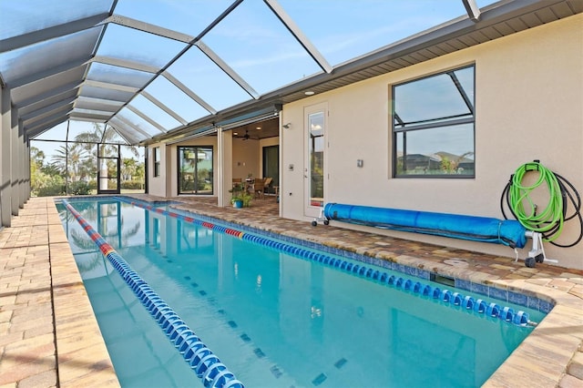 view of pool featuring a patio area, ceiling fan, and glass enclosure