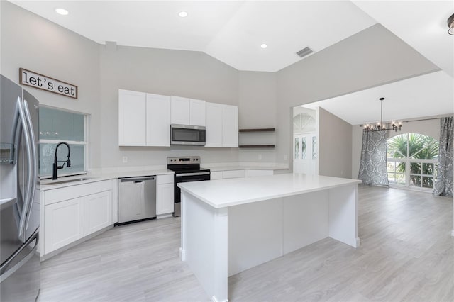 kitchen featuring white cabinets, sink, appliances with stainless steel finishes, and an inviting chandelier