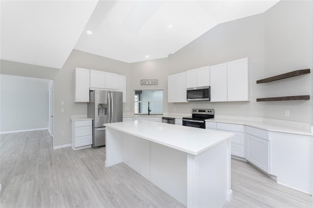 kitchen featuring white cabinets, a center island, light wood-type flooring, and stainless steel appliances