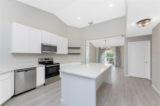 kitchen featuring appliances with stainless steel finishes, pendant lighting, an inviting chandelier, white cabinets, and a kitchen island