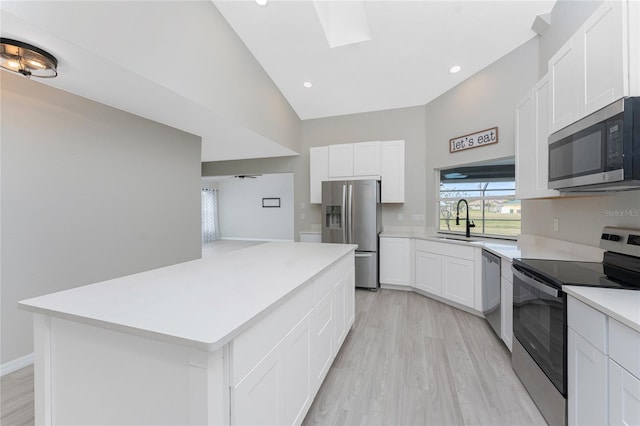 kitchen featuring white cabinets, sink, light hardwood / wood-style floors, a kitchen island, and stainless steel appliances