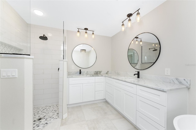 bathroom with a tile shower and vanity