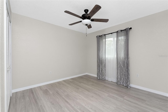 empty room with ceiling fan and light hardwood / wood-style flooring