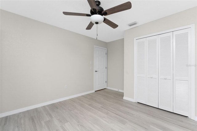 unfurnished bedroom with ceiling fan, a closet, and light wood-type flooring