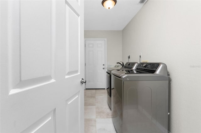 laundry room featuring light tile patterned flooring and washing machine and dryer