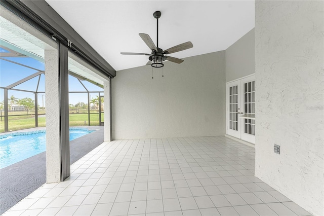 unfurnished sunroom featuring ceiling fan, vaulted ceiling, a pool, and french doors