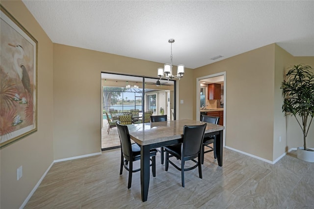 dining room with a textured ceiling and a notable chandelier