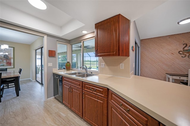 kitchen featuring wood walls, dishwasher, a chandelier, and sink