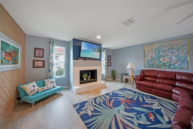 living room featuring ceiling fan and wooden walls