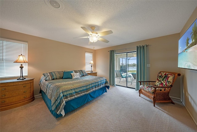 bedroom featuring access to outside, ceiling fan, light colored carpet, and a textured ceiling