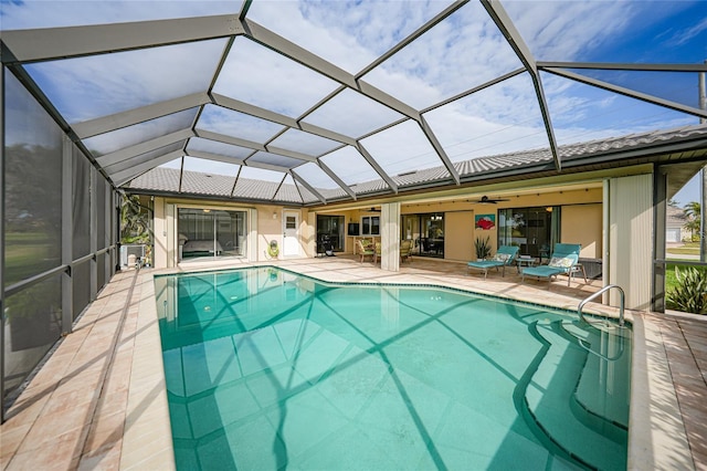 view of swimming pool with a lanai, ceiling fan, and a patio