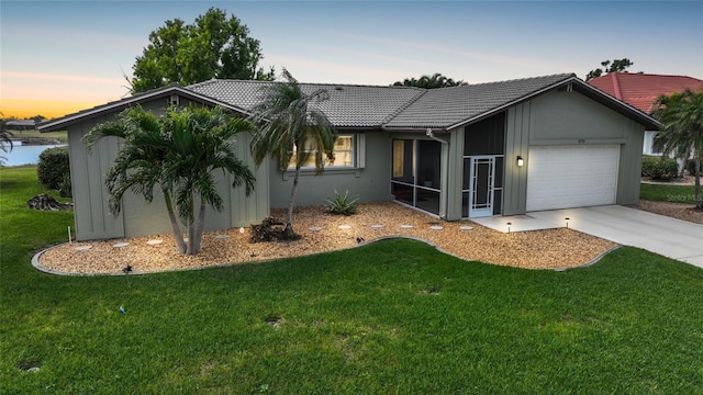 single story home featuring a lawn and a garage