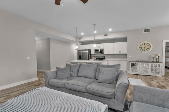 living room with light wood-type flooring and ceiling fan