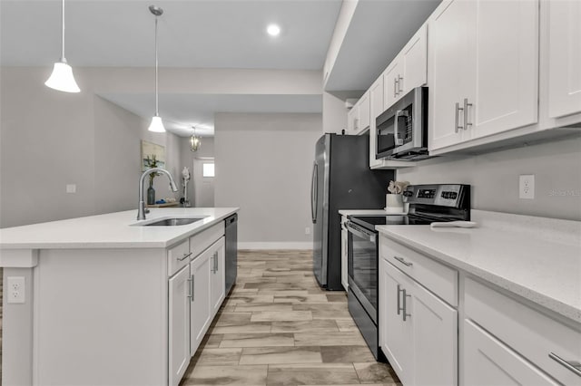 kitchen featuring appliances with stainless steel finishes, white cabinetry, pendant lighting, and sink