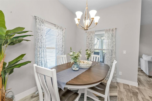 dining room with plenty of natural light, light hardwood / wood-style flooring, and a chandelier