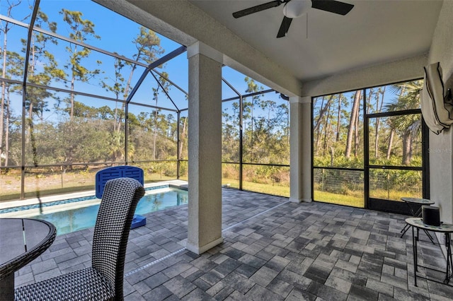 unfurnished sunroom with ceiling fan