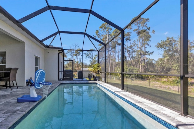 view of swimming pool featuring glass enclosure and a patio area