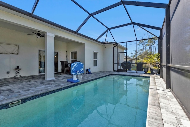 view of swimming pool featuring a patio, glass enclosure, grilling area, and ceiling fan