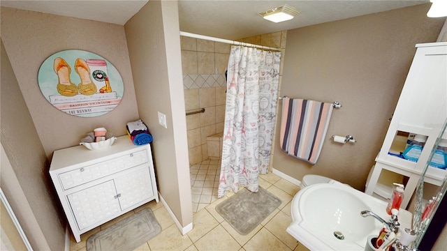 bathroom with tile patterned flooring, curtained shower, and sink