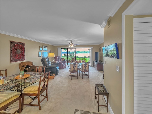 carpeted dining space featuring ceiling fan and crown molding