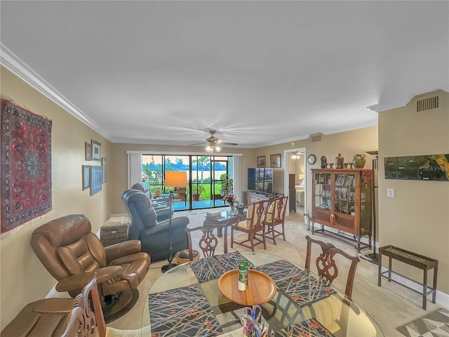 carpeted living room with ceiling fan and ornamental molding